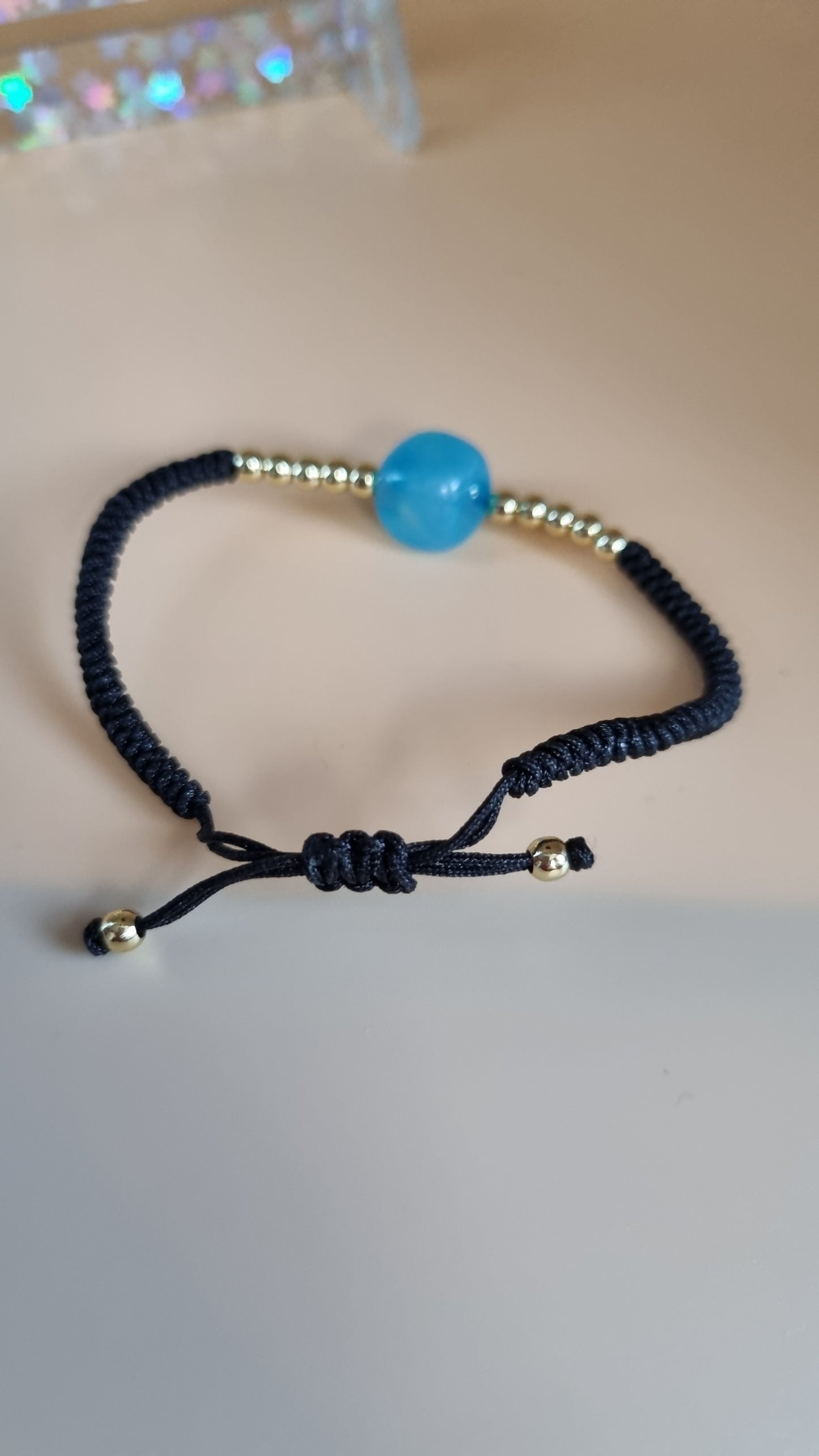 One size bracelet black color with 14.kr gold plated beads  hypoallergenic waterproof blue stone beads